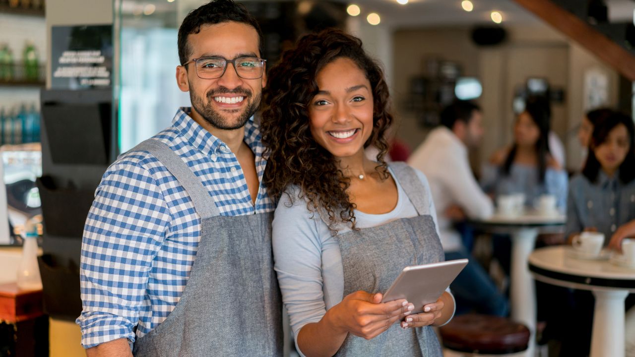 Two smiling business owners working at their business