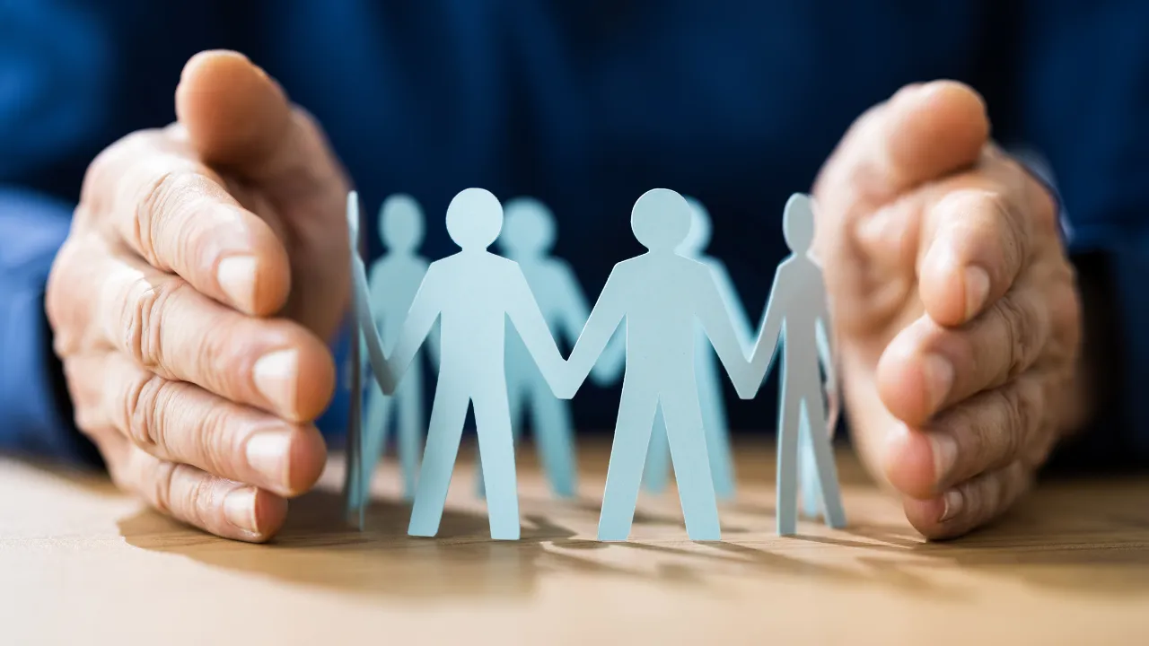 A hand protecting a group of people