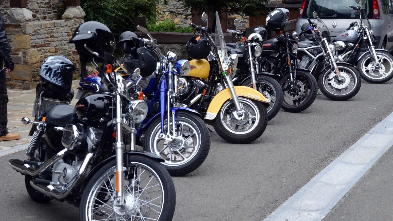A collection of motorcycles parked at the side of the road
