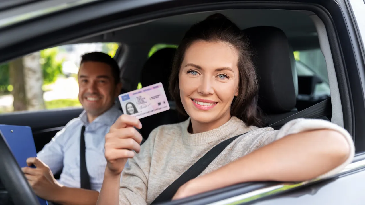 A woman in a car showing her driver's license