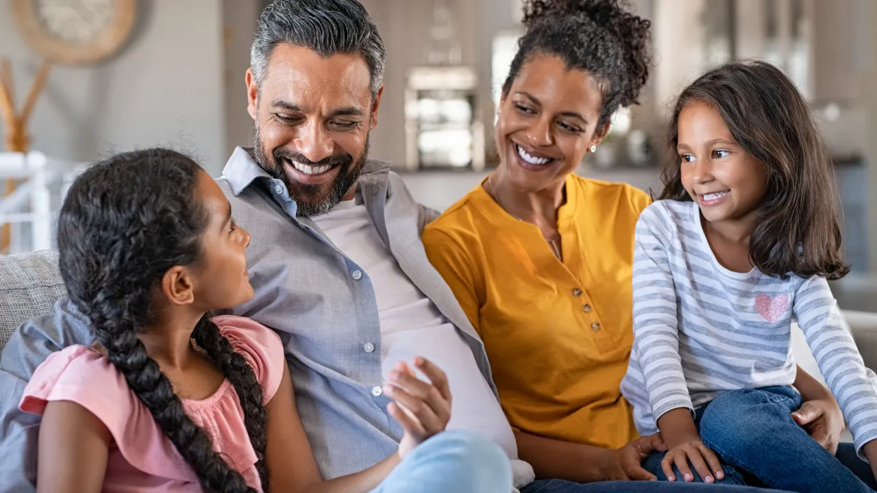 A happy family of 4 sitting on their couch
