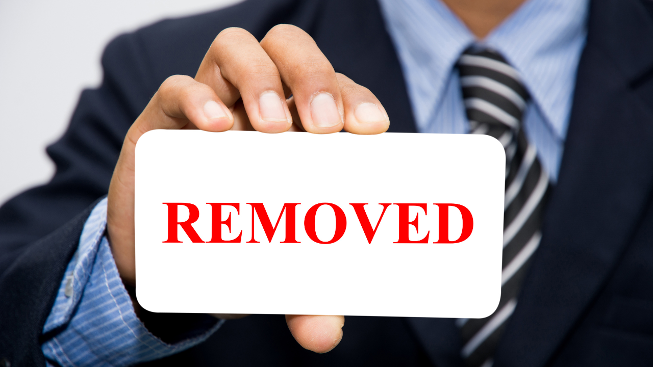 A business man holding a "removed" card