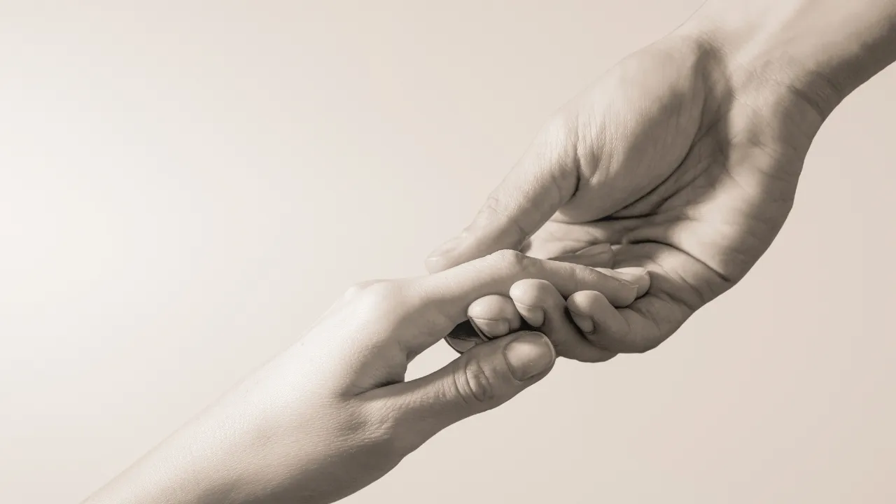 Two people holding their hands out to each other