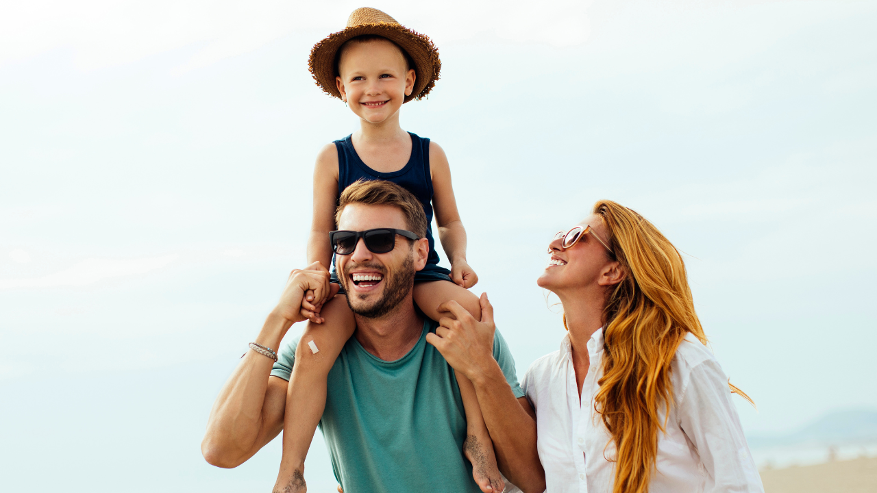 A happy family of 3 on vacation on the beach