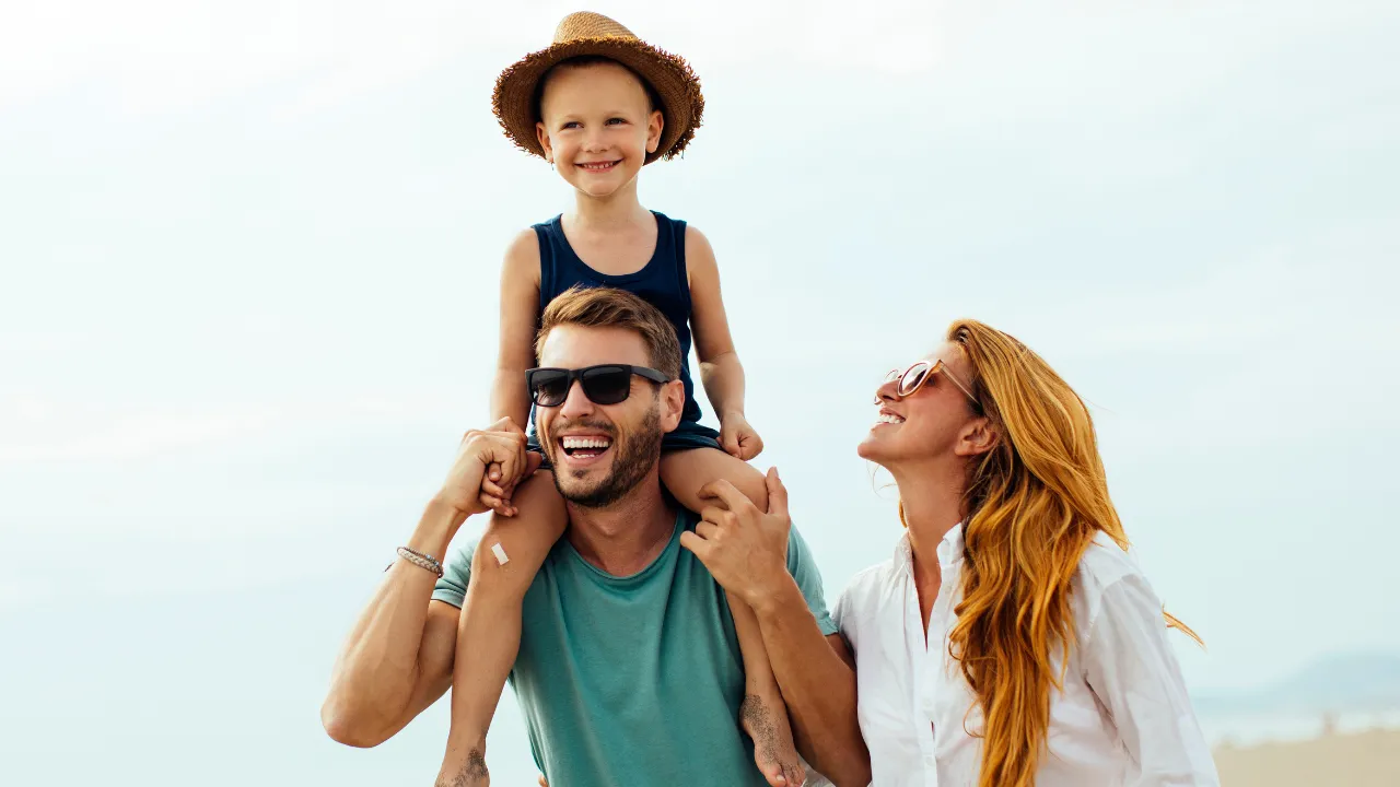 A happy family of 3 on vacation on the beach