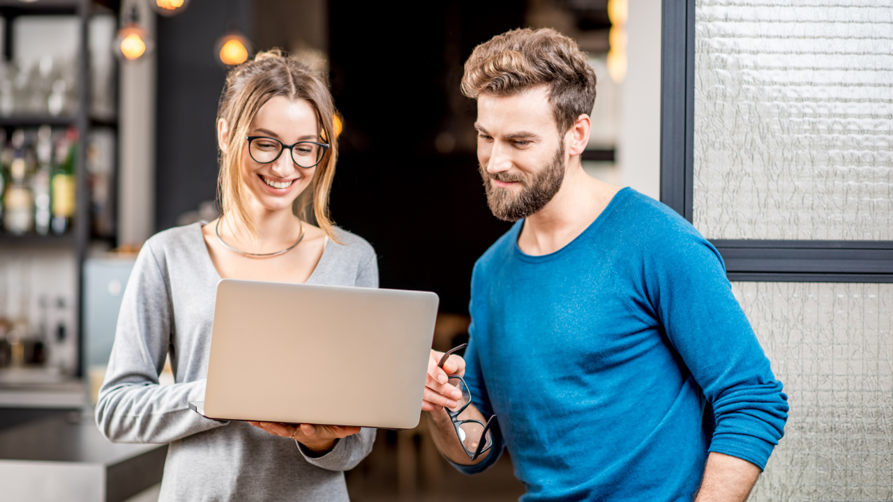 Two individuals looking at their options on a laptop