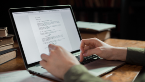 A writer working on a new project on their laptop