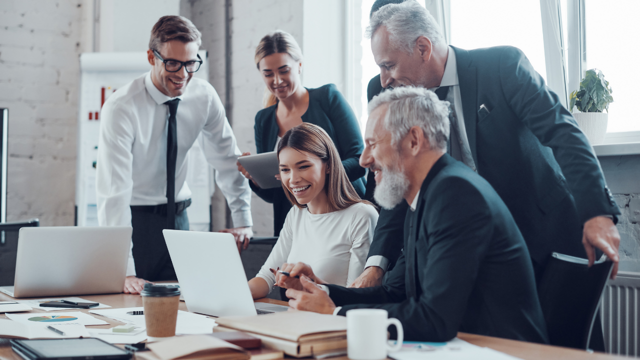 A grooup of professionals gathered around a laptop | Scott Legal, P.C. A grooup of professionals gathered around a laptop