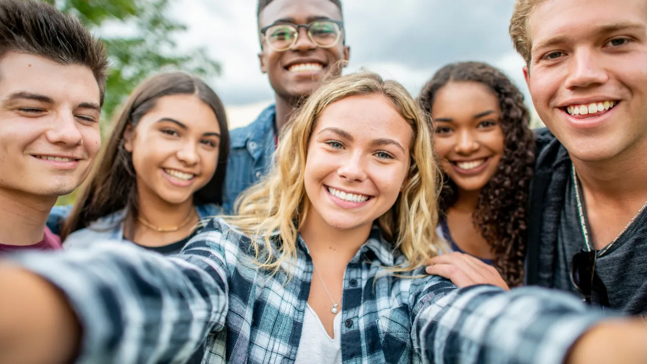 A group of teenage friends gathered together to take a photo