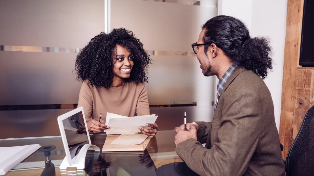 A woman conducting an interview with a man in her office