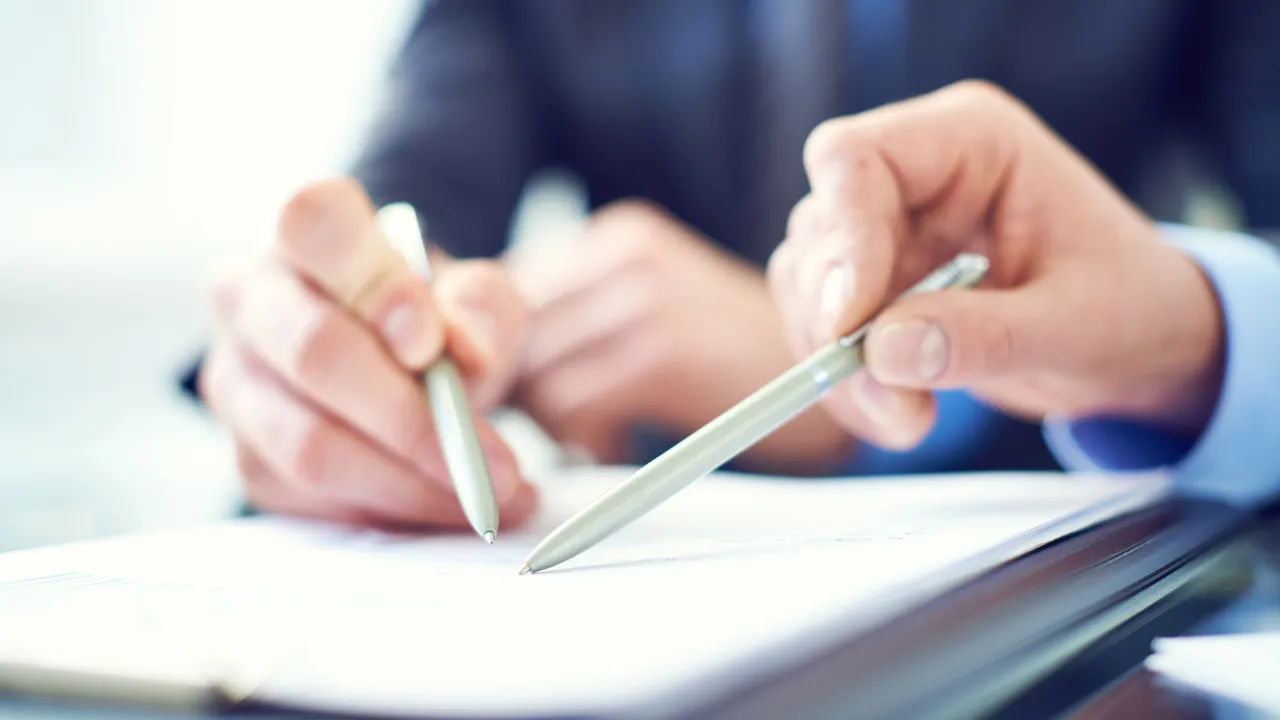 Two individuals looking over a collection of documents