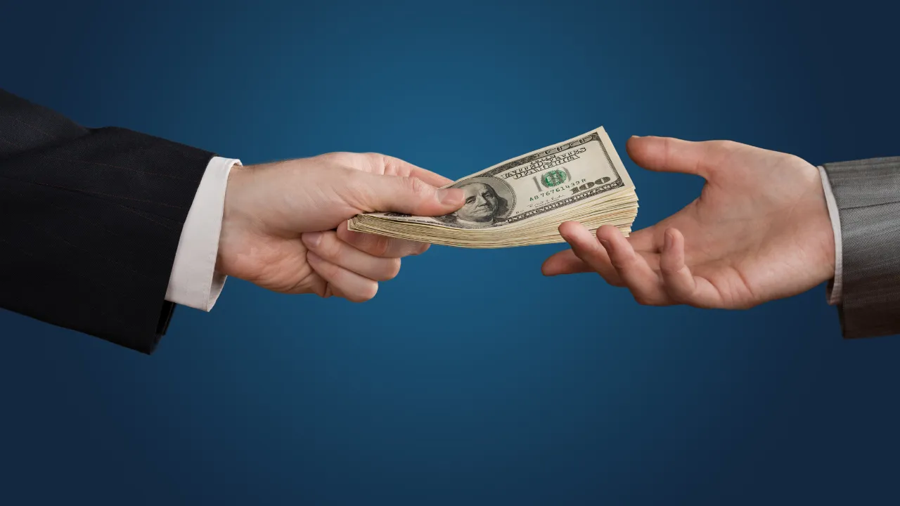 A business professional handing money to another as a loan