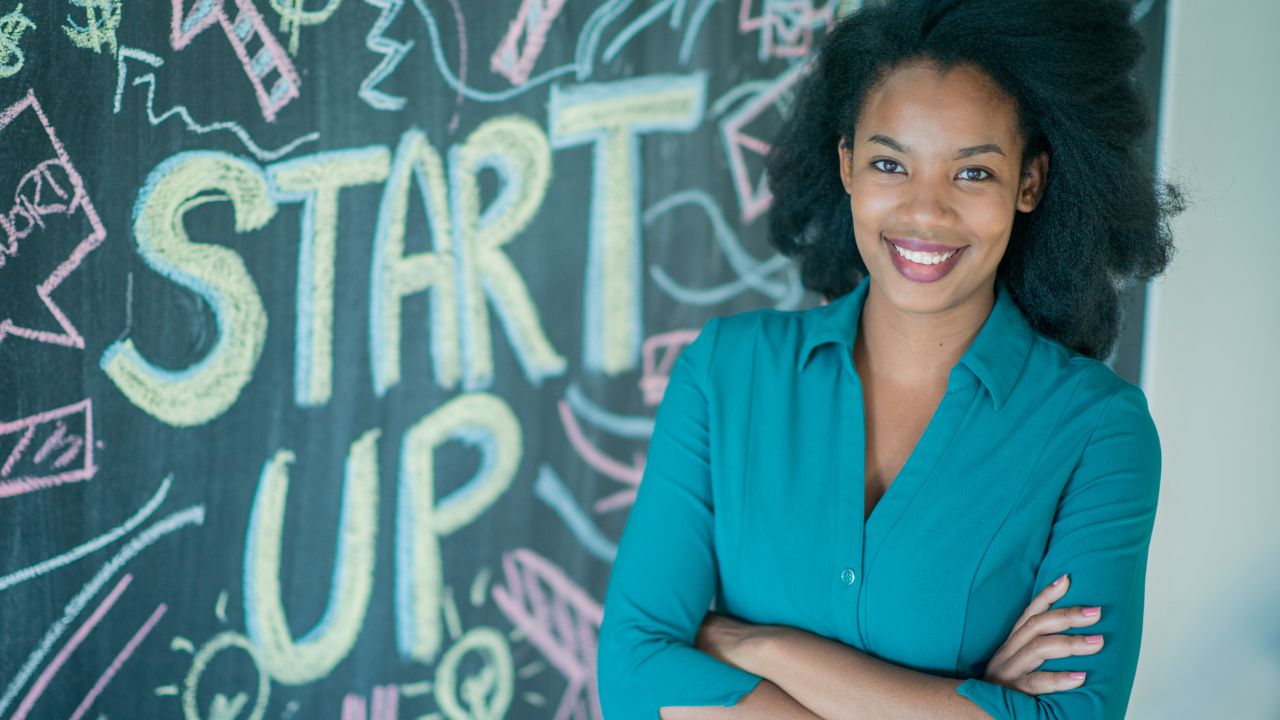 an entrepreneur standing by a start up sign