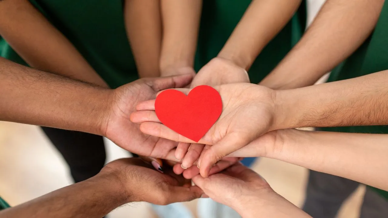 Humanitarian hands joined in solidarity while holding a heart