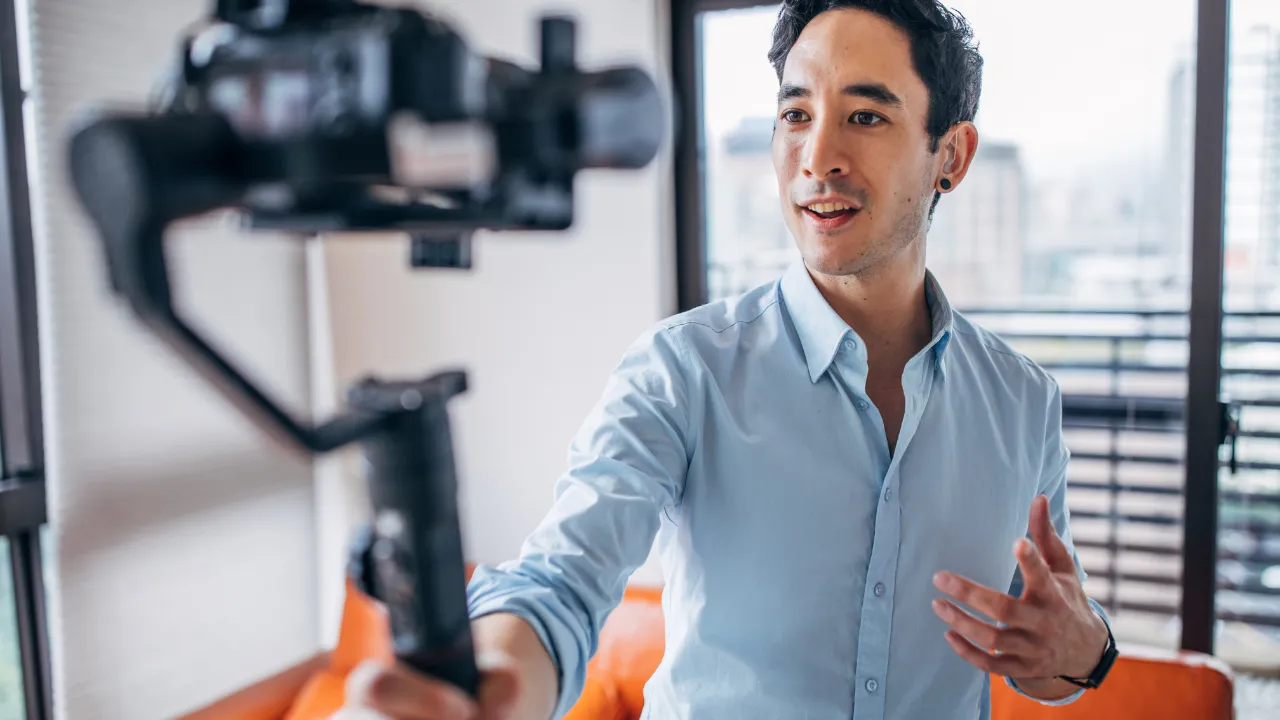 An influencer with a video camera recording himself
