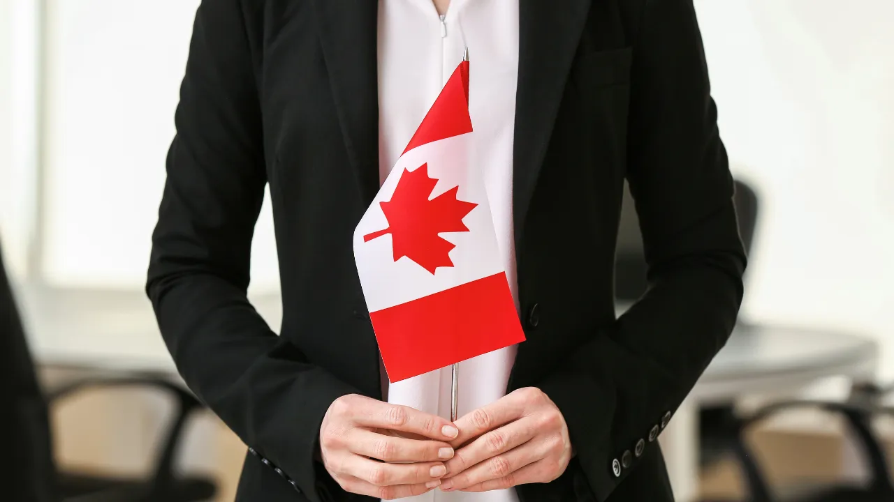 A business woman holding a Canadian flag.