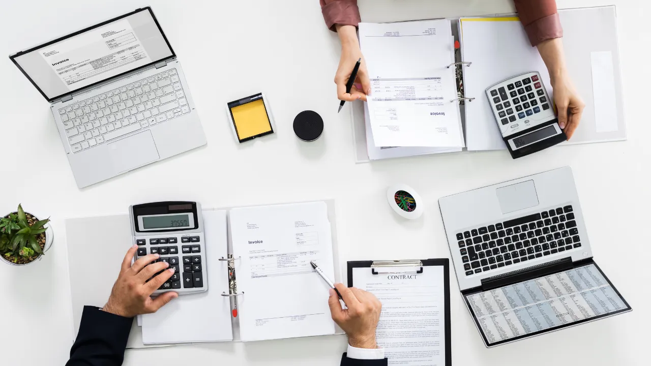 two team members doing work on their laptops at a table