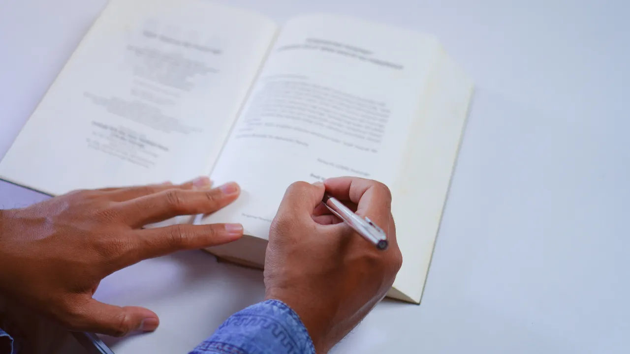 A man writing in a published book
