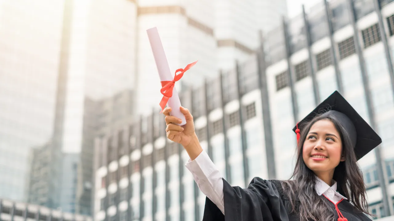 A student holding up a degree