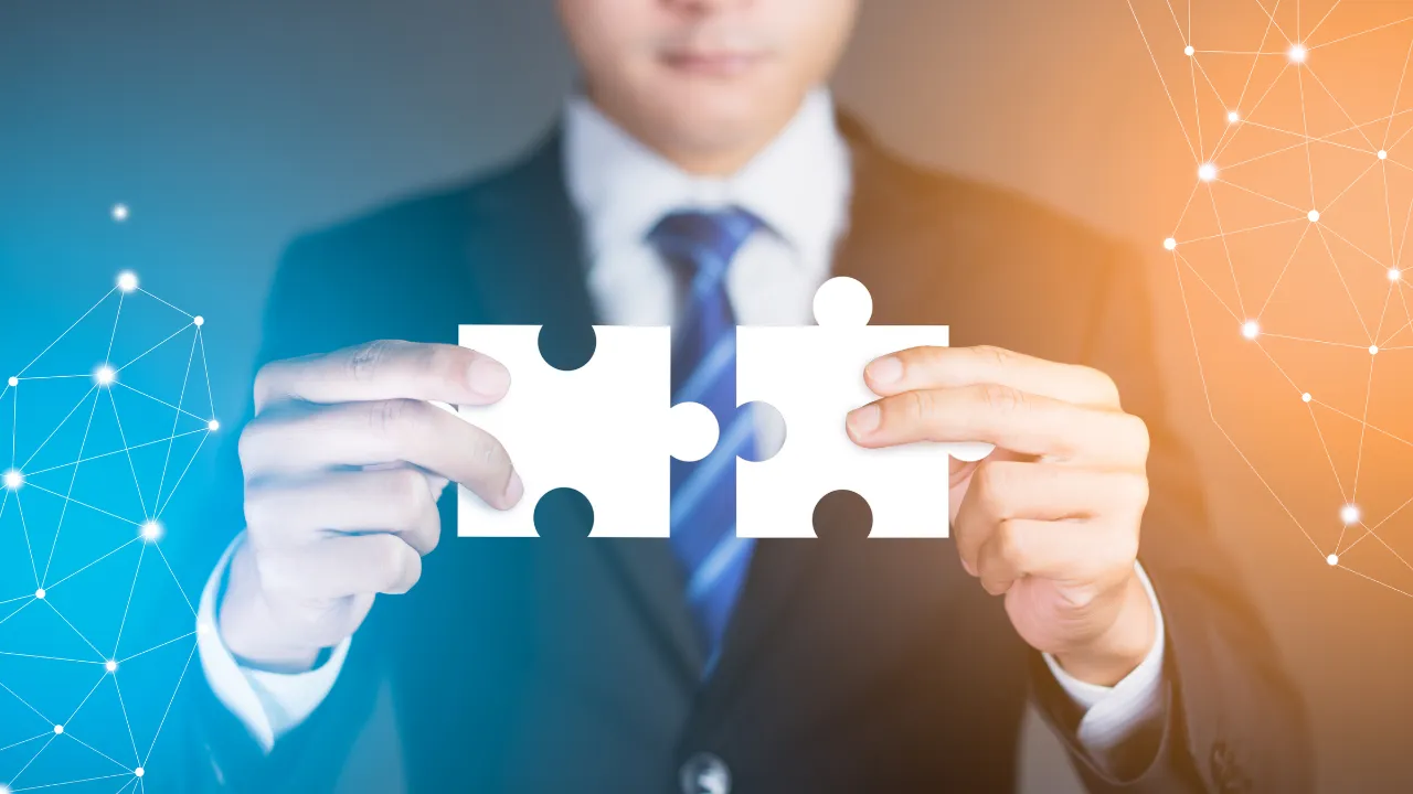 A business man holding some puzzle pieces together