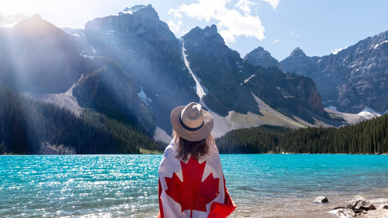 A woman travelling to see the mountains with a Canadian flag