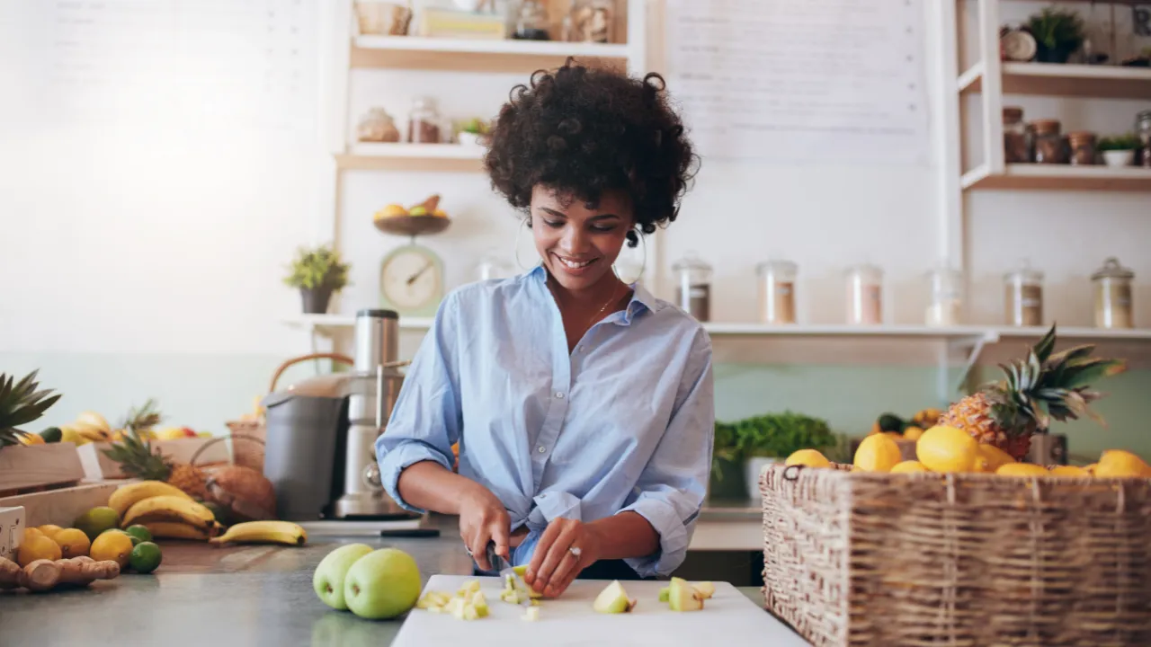 a woman working in a juice shop cutting up apples