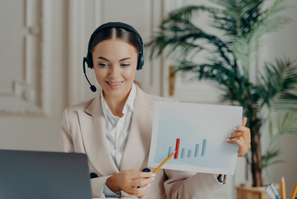 A woman on a video call holding a graph
