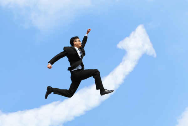 A business professional celebrating a win in an excited leap