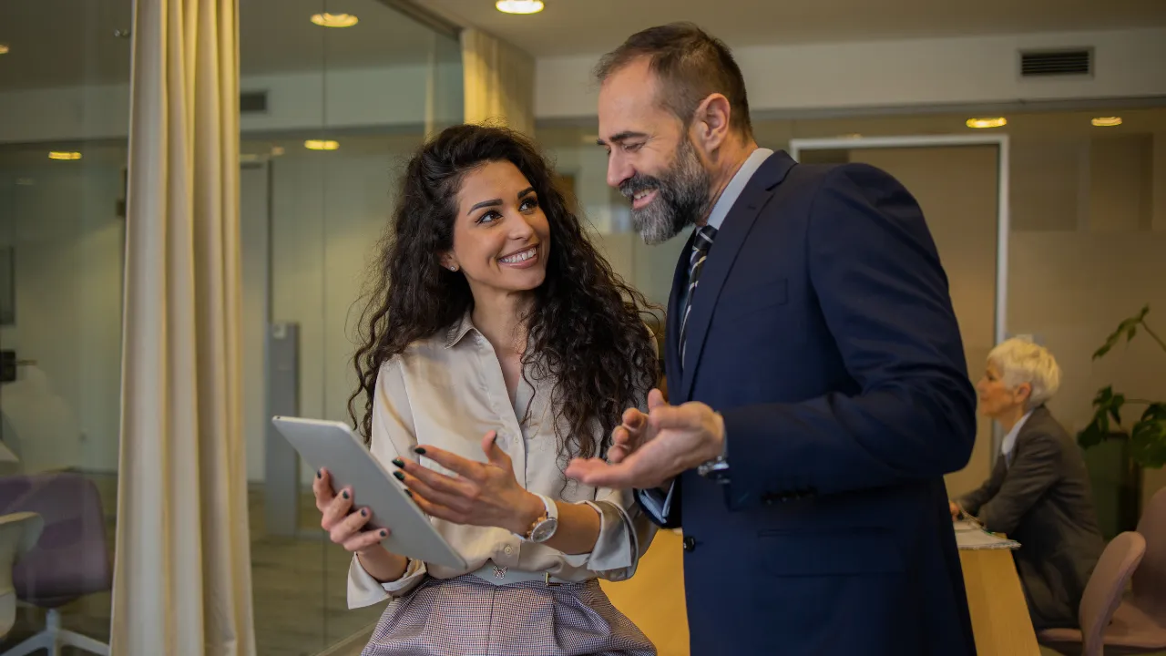 Two corporate workers consulting paper work