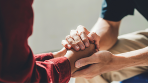Two people holding hands in solidarity