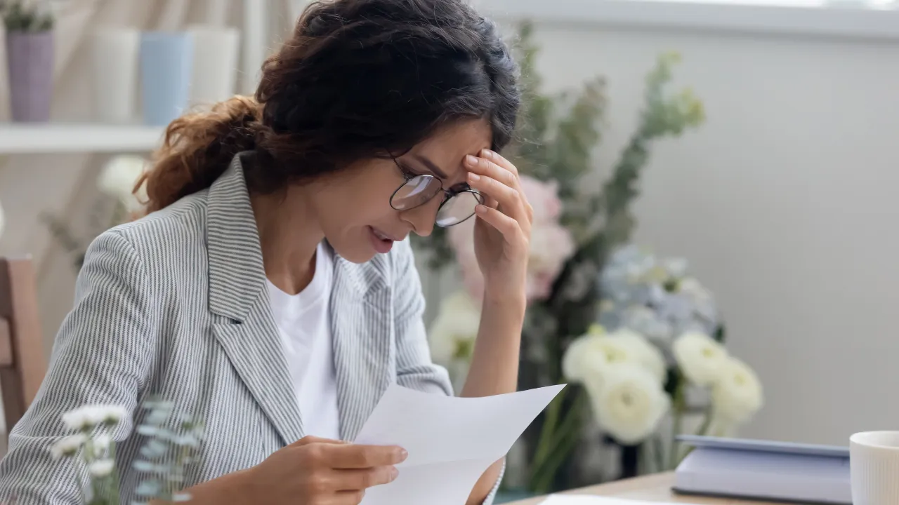 A woman reading a denial notice