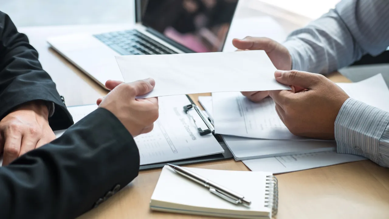 An employer handing an offer letter to a potential employee