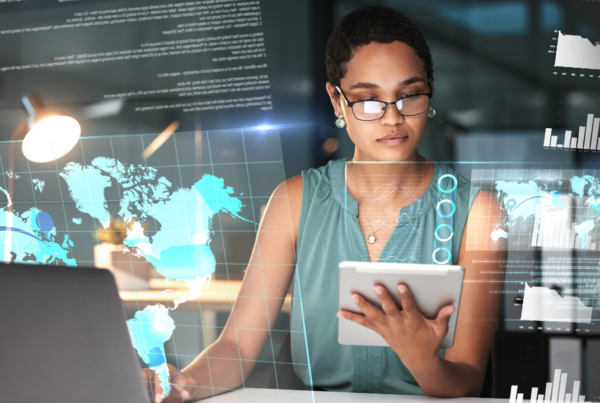 A woman working on a tablet and laptop with global images on the screen | Scott Legal, P.C. A woman working on a tablet and laptop with global images on the screen