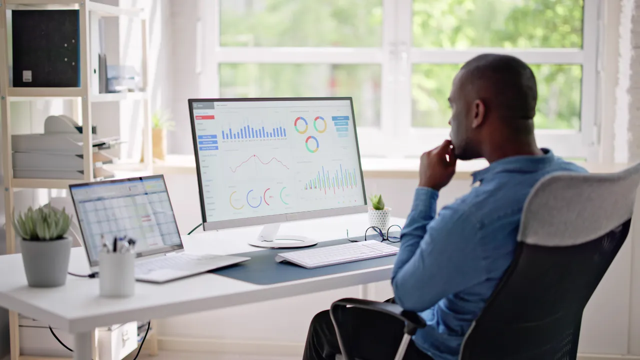 A business professional consulting charts on his computer