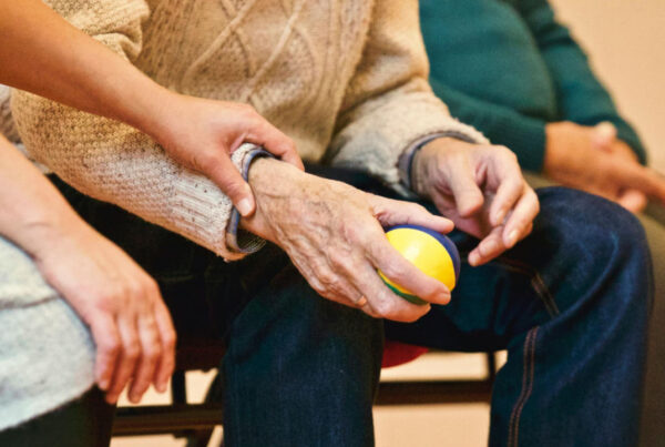 E-2 Visa Approved for Senior Care Business | Scott Legal, P.C. Senior citizen hand being held by another person.