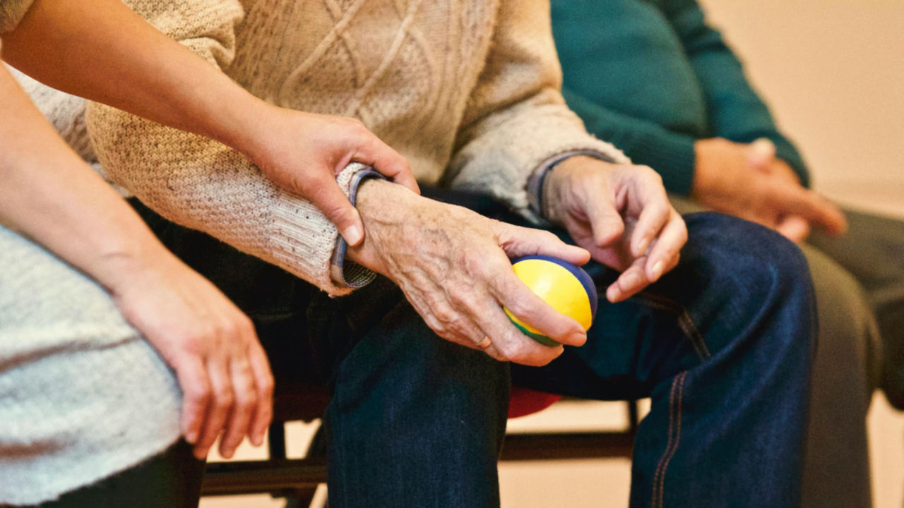 E-2 Visa Approved for Senior Care Business | Scott Legal, P.C. Senior citizen hand being held by another person.