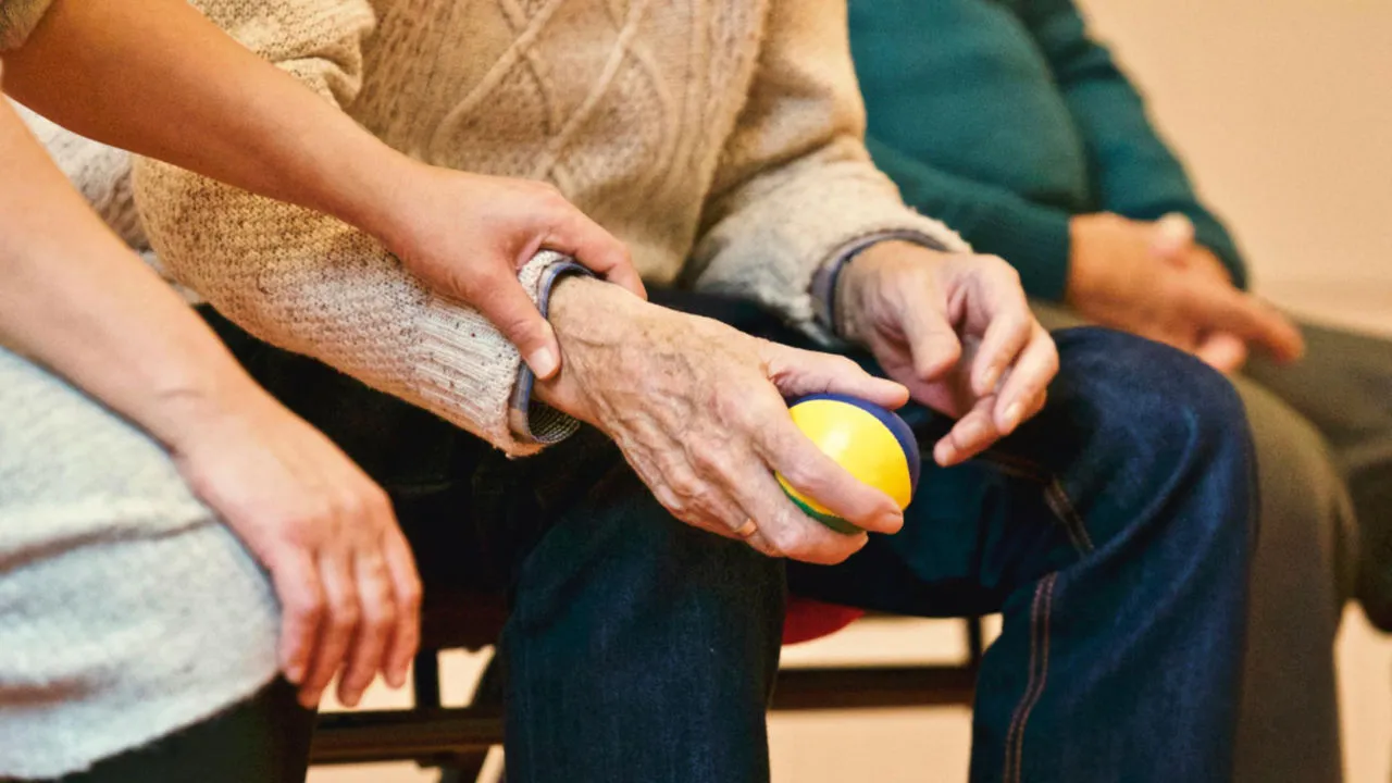 Senior citizen hand being held by another person.