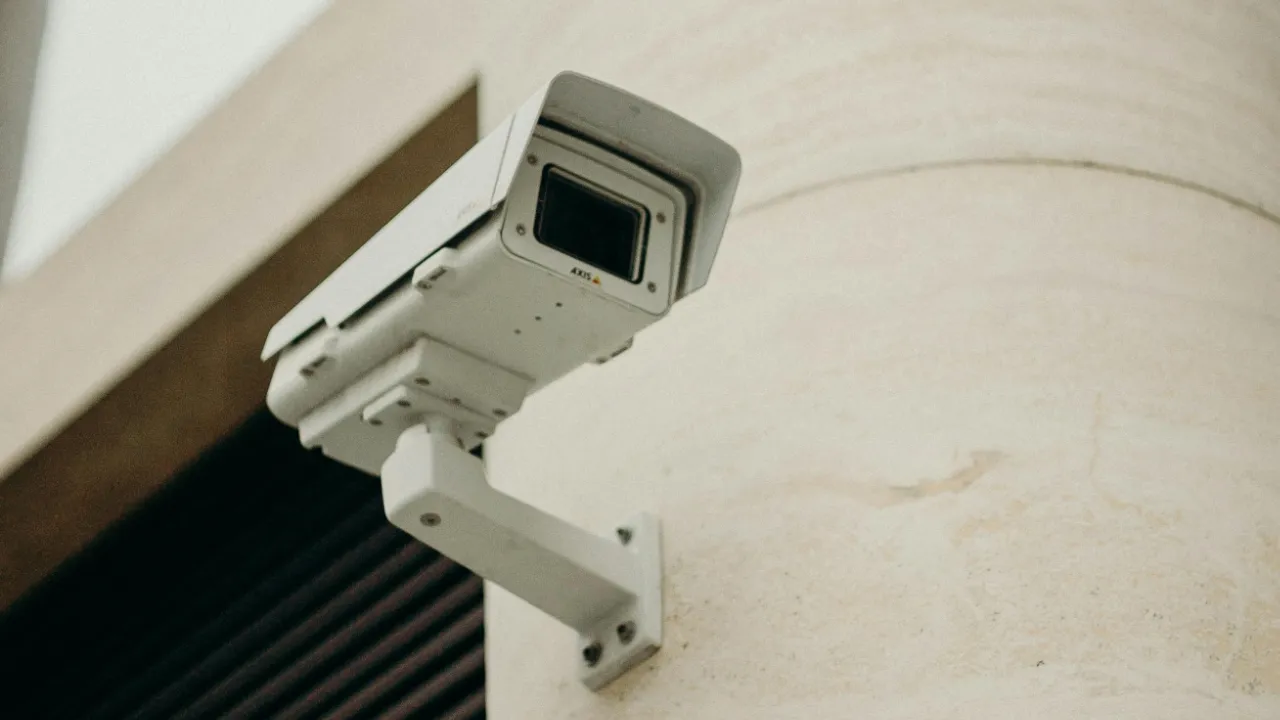 Surveillance camera mounted on a building, symbolizing a growing U.S. security business under the E-2 visa program