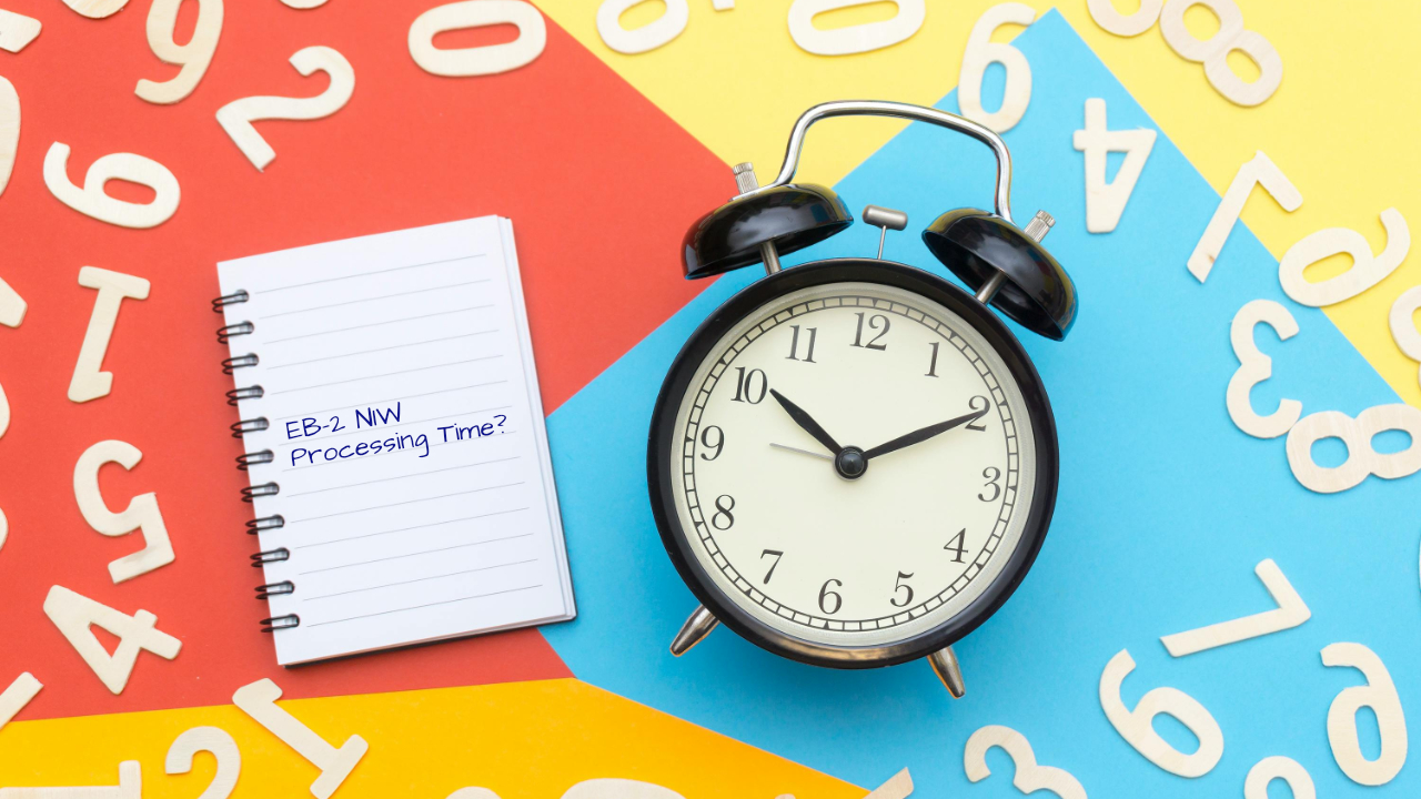 Clock and notebook with text “EB-2 NIW Processing Time?” representing green card processing timelines