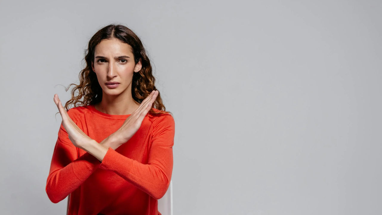 EB-5 Visa Application Denial | Scott Legal, P.C. A woman making an "X" sign with her hands.