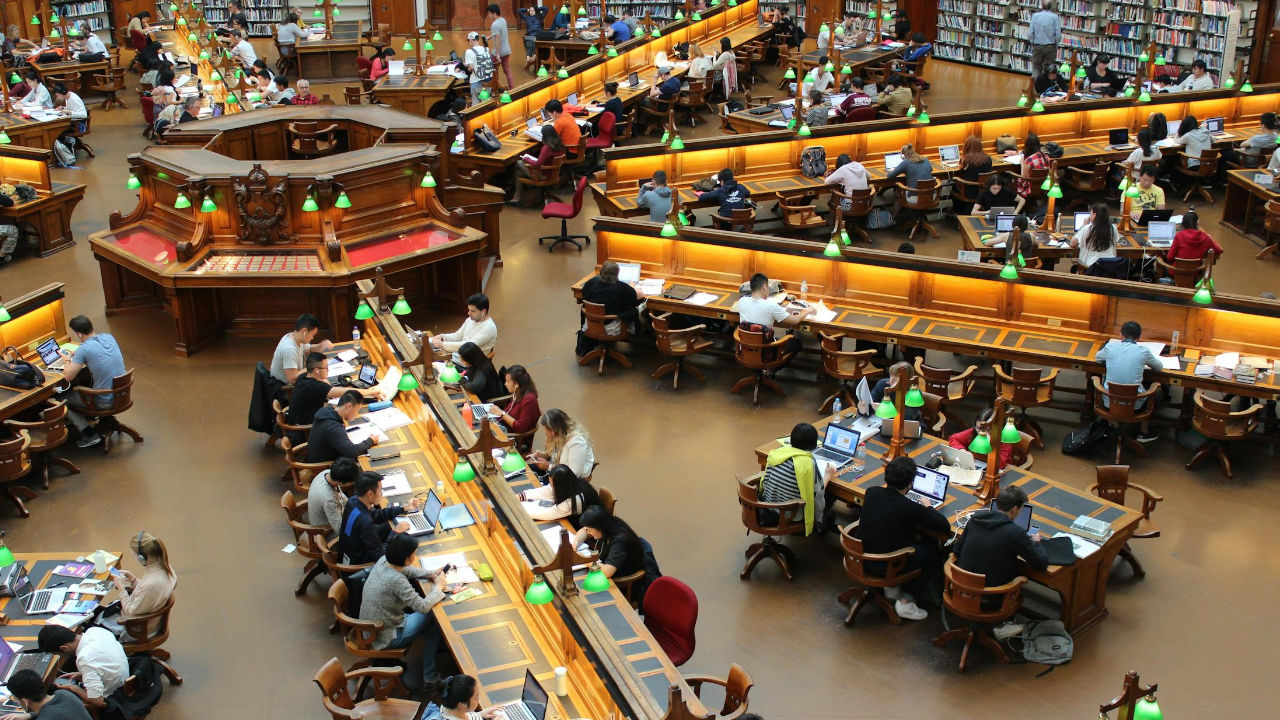F-1 Student Visa | Scott Legal, P.C. A library full of students, some possibly on an F-1 Visa.