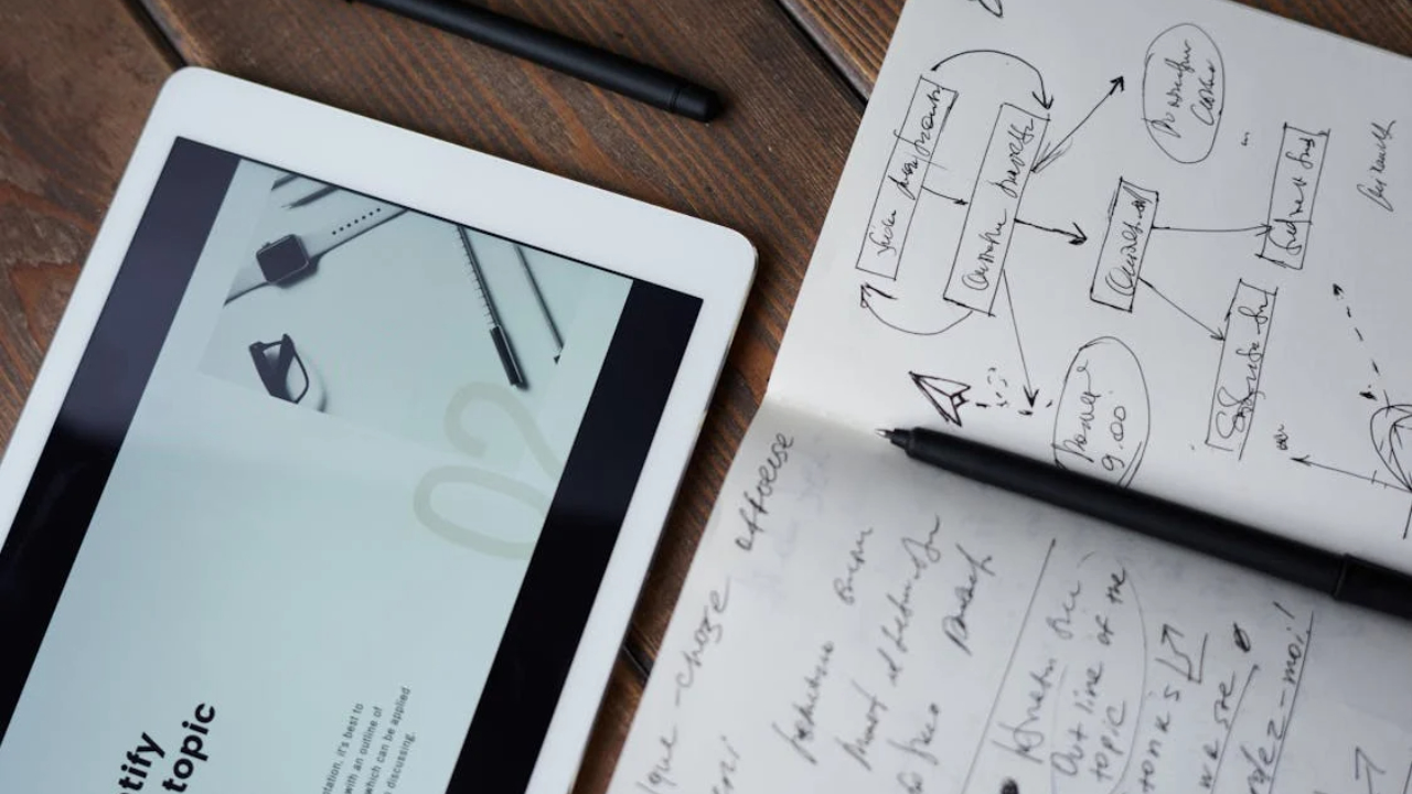 Tablet and open notebook with handwritten strategy notes representing a marketing professional’s EB1A success