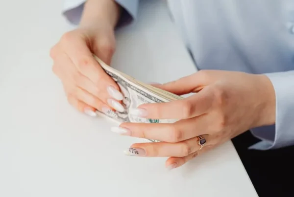 Hands of a woman holding U.S. dollar bills, symbolizing prevailing wage in employment-based immigration