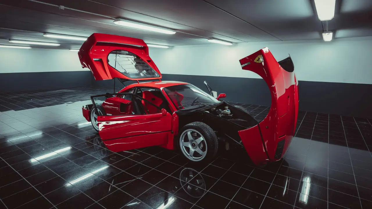 Red luxury car in a high-end garage representing a successful E-2 visa approval for a Canadian investor