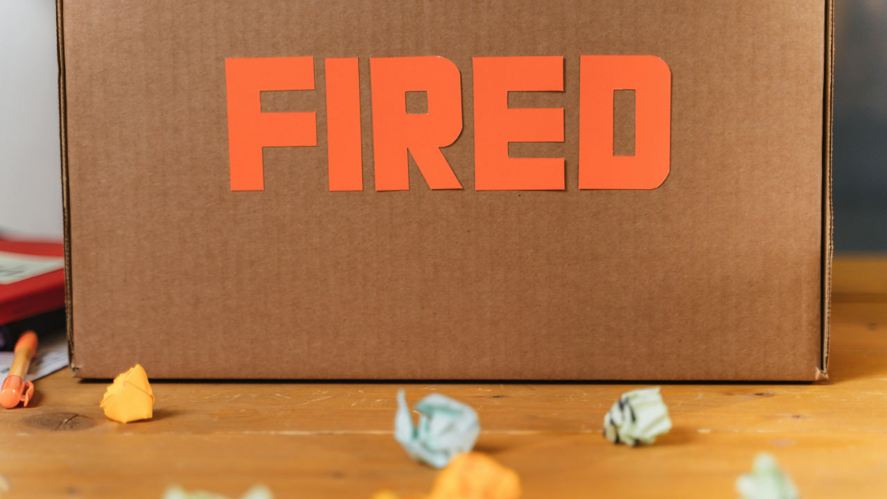 Cardboard box with “FIRED” sign symbolizing employee layoffs affecting PERM labor certification