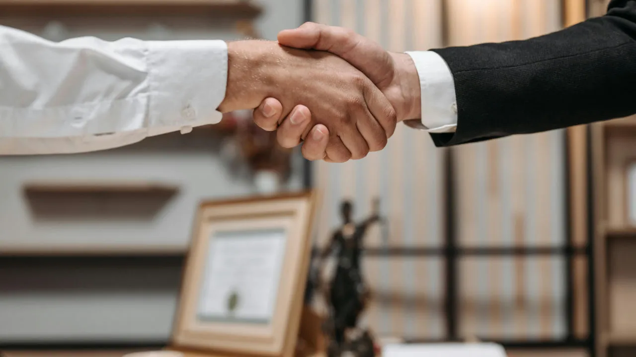 A firm handshake between a U.S. employer and a professional, finalizing a cost-effective hiring agreement with a TN visa.