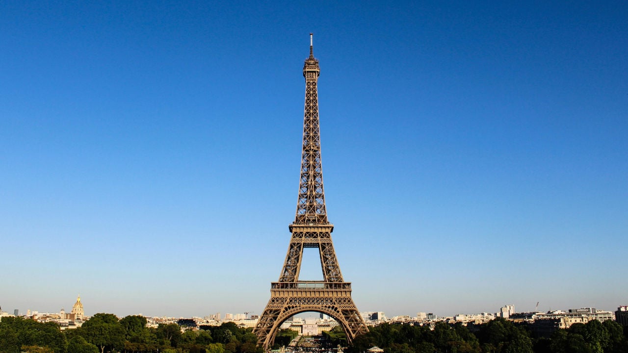 The Eiffel Tower against a clear blue sky, representing the freedom and flexibility for E-2 visa holders to spend extended time abroad.