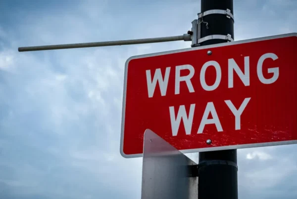 A red "WRONG WAY" street sign, symbolizing the serious immigration consequences of an incorrect I-94 record.