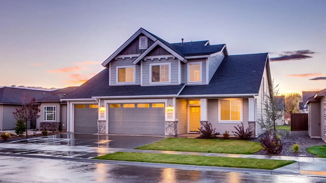 A modern suburban house at dusk, used to illustrate personal housing costs that are not part of an E-2 visa investment.