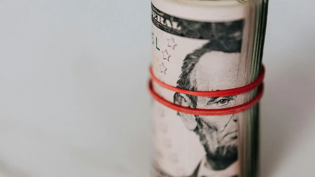 A roll of US dollars bound by a rubber band, symbolizing the return of an EB-5 investment.